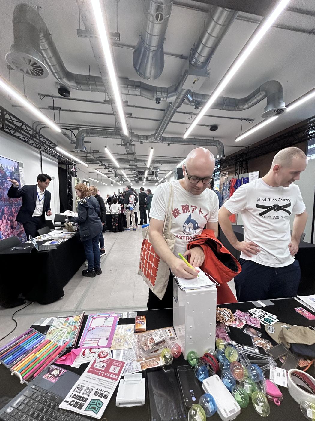 A visitor writing his answer in the MUDA notebook at the booth.